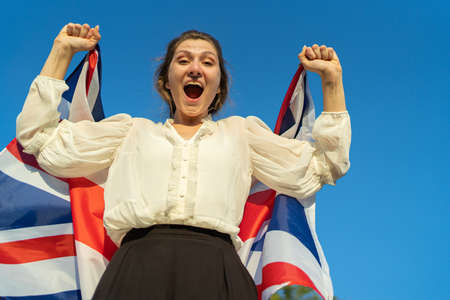 Winner in the UK. Woman with British flag rejoices in success and shouts at the cameraの写真素材