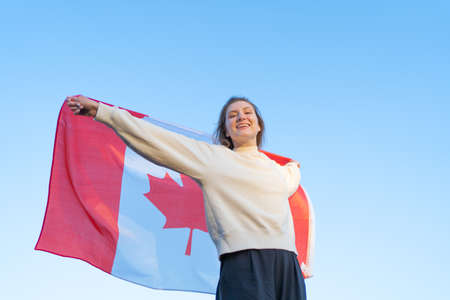 Canada Day. The national symbol of the country. Canadian flag waving in womans handsの写真素材