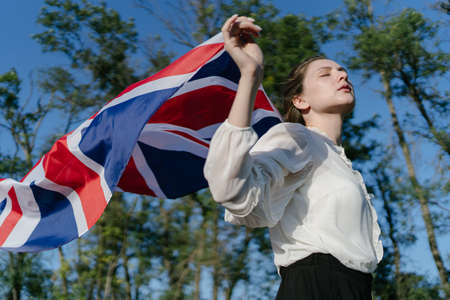 Immigration to Great Britain. Patriot of GB with the national flag of his countryの写真素材