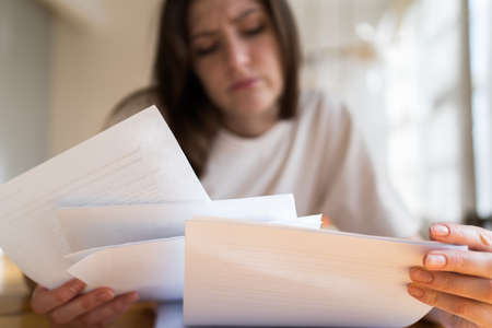 The manager cant handle the workload. A lot of documents and accounts in the womans hands close upの写真素材