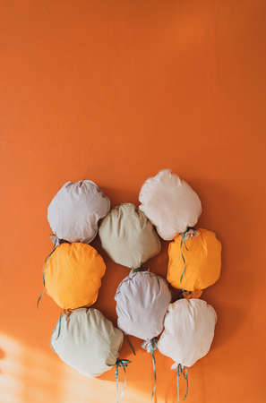 Beautiful decor on the orange wall. Multi-colored soft pillows in the photo zone