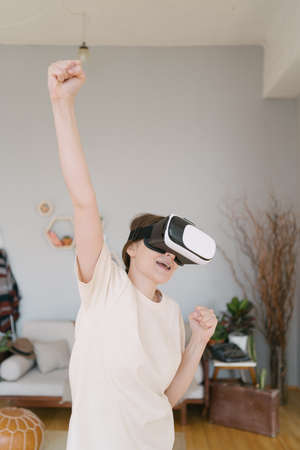Vertical shoot - An excited young woman celebrates winning in cyberspace. Online competition
