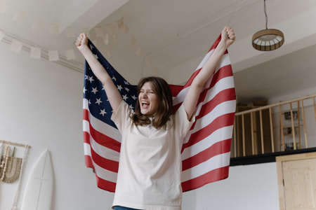 American winner. Victory. Lucky woman raises US flagの写真素材