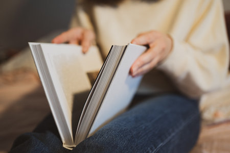 A young woman opens the book. Learning information. White big book on feet close-up