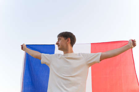 Immigration to France. Demonstration of the French flag. Patriot with national symbolの写真素材