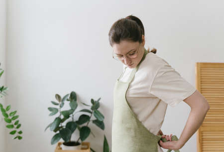 Professional florist wears an apron in a flower shop. Concept of people and small business. Working employeeの写真素材