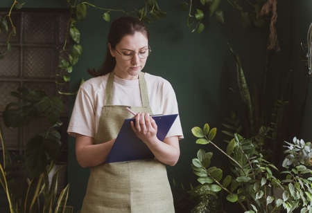 Small business. A woman with a tablet checks the availability of goods for sale. Recalculation and inventory in the storeの写真素材