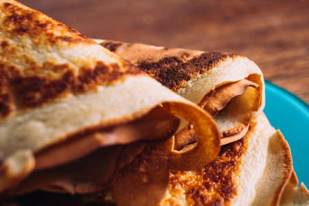 lot of pancakes on a blue  plate on a blurred backgroundの写真素材