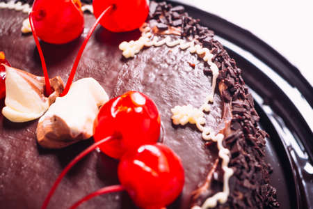 Delicious fresh chocolate  cake with cherries on a light background