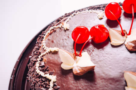 Delicious fresh chocolate  cake with cherries on a light backgroundの写真素材