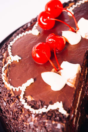 Delicious fresh chocolate  cake with cherries on a light background