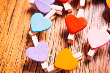 colorful  clothespins with little hearts on wooden background close upの写真素材