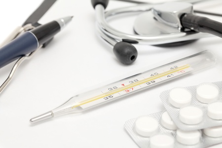 Medical still-life with stethoscope, clipboard, pen, thermometer and tabletsの写真素材
