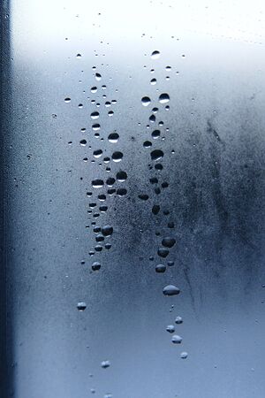 drops of water on a window pane against the skyの写真素材