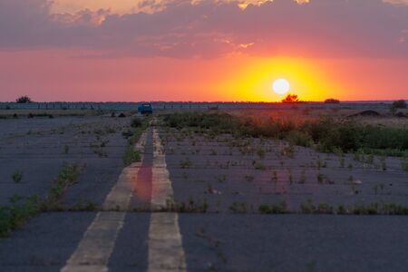 beautiful sunset over horizon with fog on abandoned airport runway
の写真素材