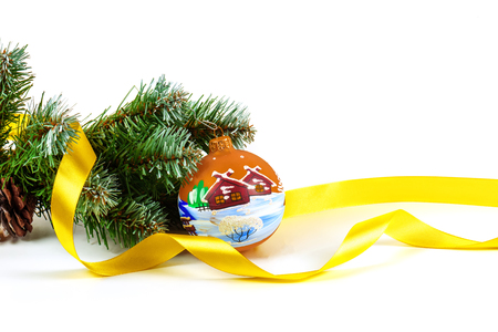 Artificial fir-tree branch with a ball, a background for New year and Christmas on a white background.の写真素材