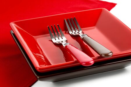 Red plate and two forks on a red napkin.の写真素材