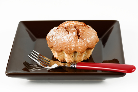 Crispy cake on a dark plate with a fork on a white backgroundの写真素材