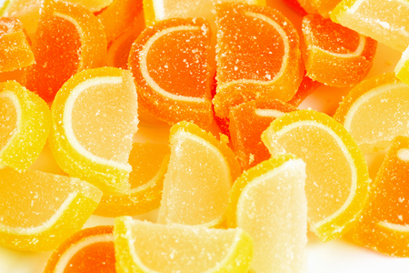 Marmalade in the form of lemon and orange slices on a white backgroundの写真素材