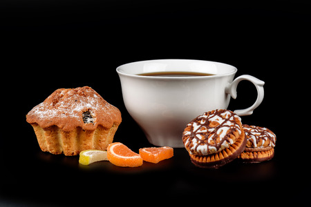 Cake, chocolate chip cookies and a cup of coffee on a black backgroundの写真素材