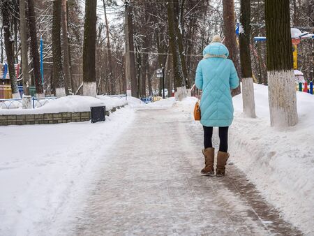 Young girl goes on a winter park.の写真素材