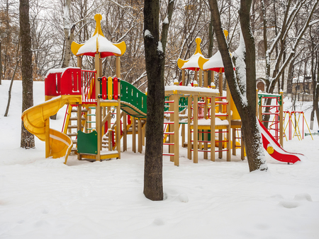 Snowy colorful playground in a park in winter.の写真素材
