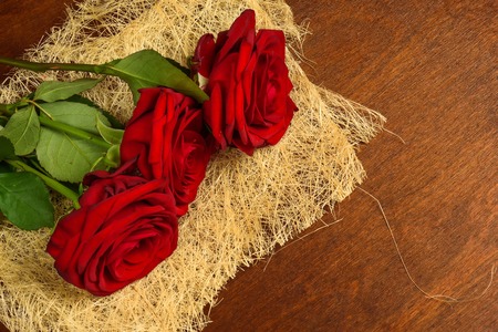 Bouquet of beautiful red roses on a dark wooden background closeupの写真素材