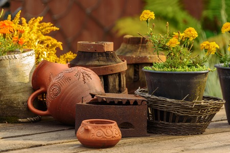 Clay pot, basket with flowers on a wooden table. Naturmot in the old style.の写真素材