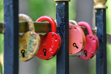 Russia, Moscow region, Ramenskoye May 10, 2019. Closed locks on the fence of the bridge. Wedding tradition.のeditorial素材