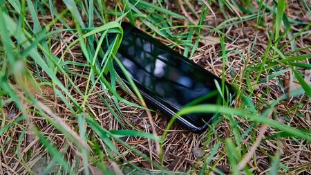 A lost mobile phone lies on the grass close-up. Phone loss.の写真素材