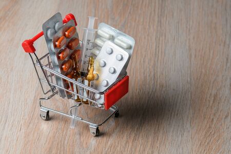 Packaging of medical tablets in the shopping cart. Purchase of medicinal tablets. Protection from virus infection.の写真素材