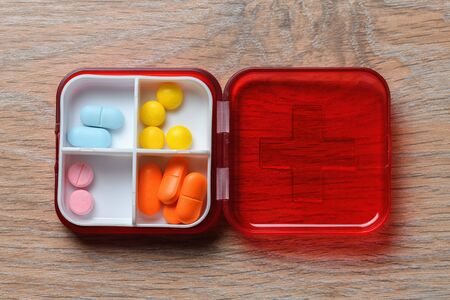 Tablets in a red pill box. Drugs for the treatment of coronavirus. A reminder of taking the pill.の写真素材