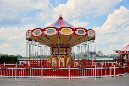 Old carousel in a holiday park. Horses and airplane on a traditional fairground vintage carousel. Merry-go-round with horses.の写真素材