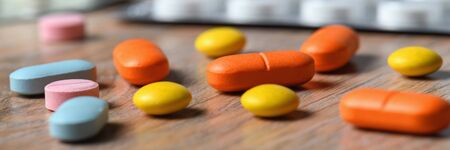 Assorted colored tablets and tablet packaging close-up on the table. Concept of protection and treatment of coronavirus infection.の写真素材