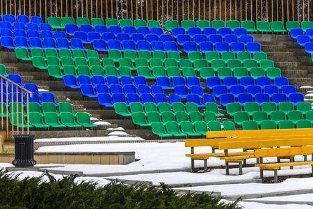 Spectator seats in the snow in winter. Empty seats of an amphitheater in a winter Park.の写真素材
