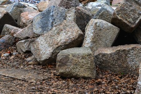 A pile of granite stones on the ground. Granite stones piled in a pile.の写真素材