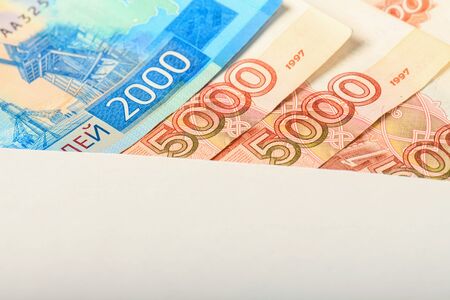 Cash notes in a white postal envelope. Russian money in a postal envelope. Bills in an envelope.