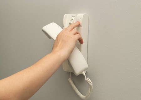 Hands opening door through intercom. Using door bell phone, doorphone, entryphone, videophone call