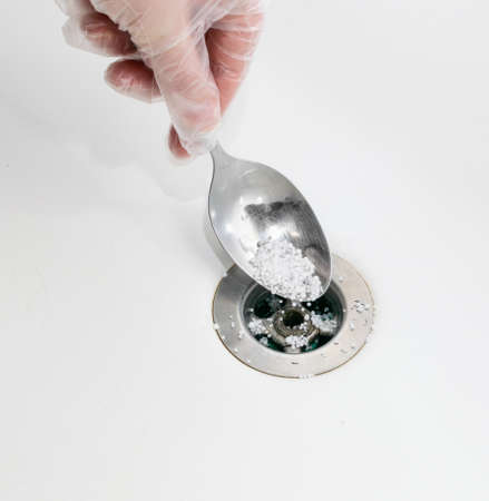Drain blockage removing with acid granules. Unclogging sink drain with chemical agentの写真素材