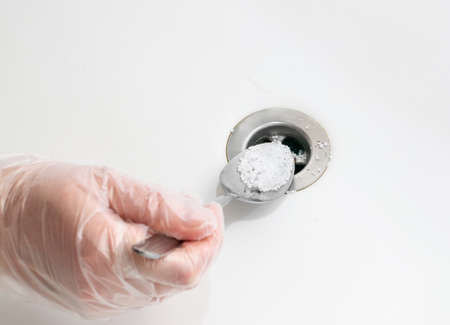 Drain blockage removing with acid granules. Unclogging sink drain with chemical agent