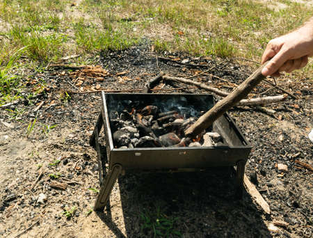 Small grill, portable barbecue, bbq with flame and smoke. Mini barbecue for outdoor recreation,...