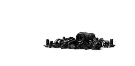Black computer bolts isolated. Heap of small bolts, screws and nuts on white background side view