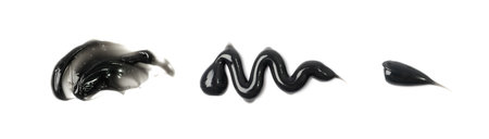 Black cream smear isolated. Dark gray volcanic clay smudge, spilled coal gel set, smudged eyeliner, charcoal toothpaste, mud mask for face, black cream smear on white backgroundの写真素材