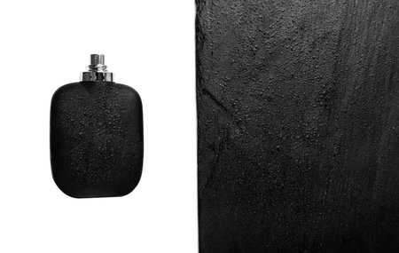 Men perfume on black stone background. Black bottle parfume, luxury aroma mockup, male cologne dark glass bottleの写真素材