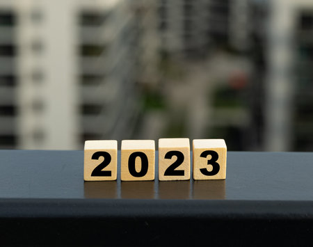 Blank wooden blocks with 2023 on blurred city background. Wooden cubes calender, new year wooden...