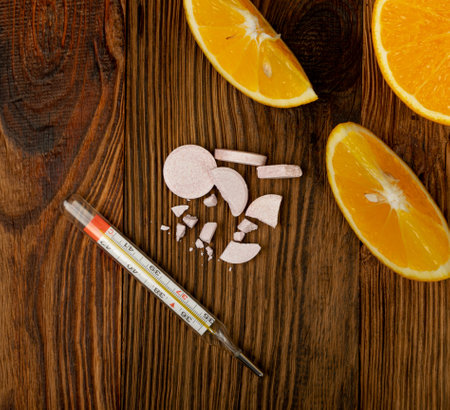 Effervescent orange tablets with medical thermometer. Fizzy fruit tablets pile, disease prevention...