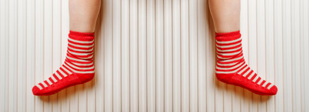 Warming Feet on White Radiator, Man Warms his Feet at Home, Cold Winter, Expensive Electricity Saving Concept, Copy Spaceの写真素材