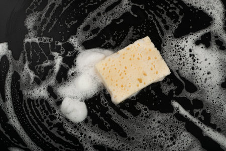 Natural Soapy Sponge with Foam, Eco Brown Sponges, Eco Friendly Hygiene Accessory, Scotch Brite Dishwasher on Black Background, Copy Spaceの写真素材