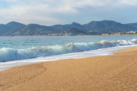 Sea Waves on Sandy Beach Texture Background, Transparent Ocean Water, Blue Sky, Golden Sunny Shore Pattern, Summer Mockup with Copy Spaceの写真素材