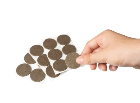 Adhesive Felt Pads Floor Protectors Isolated, Anti-Skid Felt Stickers for Chair Legs, Hand Holds Anti-Noise Coating, Furniture Floor Careの写真素材